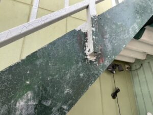 滋賀県大津市で戸建て住宅の鉄骨階段塗装、古い塗膜を剥離させるためのリムーバー剤を塗布後、塗膜が剥げた状態のアップ、深緑色の下地が見える状態