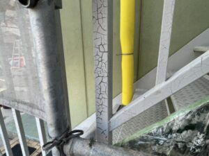 滋賀県大津市で戸建て住宅の鉄骨階段塗装、施工前で手摺りの柱の塗膜はひび割れ剥離している、塗装前の養生をしている様子
