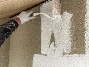 京都市西京区の中古物件の外壁塗装現場にて２階外壁をローラーで下塗り作業している様子