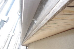 京都市西京区の中古物件の外壁塗装現場にて２階軒天周りの施工前、木部の劣化が目立つ様子