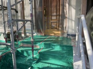 京都市西京区の中古物件の外壁塗装現場にて玄関廻りの養生にノンスリップシートを敷いている様子
